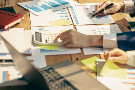 business people meet with design ideas business planning Picture of two young businessmen holding pens and graph papers at a meeting discussing charts and graphs showing successfulの写真素材