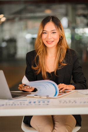 Asian female freelancer working using laptop computer in modern office make an account analysis report real estate investment information Business finance and tax system concept, vの写真素材
