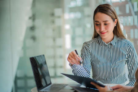 Two Asian businesswomen discussed their ideas at a meeting.
Two people discuss working on investment...