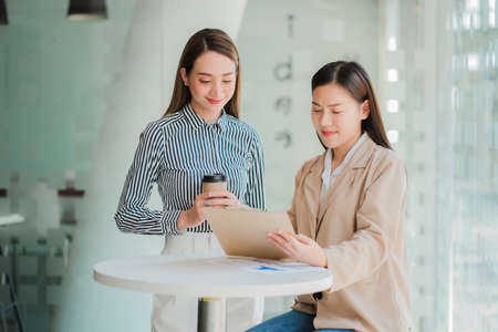 Two Asian businesswomen discussed their ideas at a meeting.
Two people discuss working on investment...