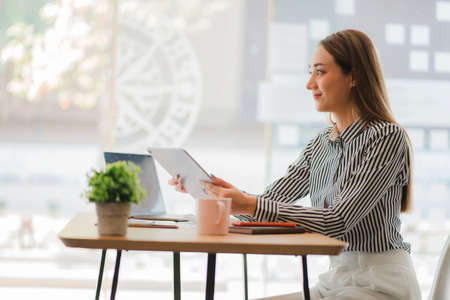 young businesswoman looking at financial data from laptop She is analyzing, calculating, examining...