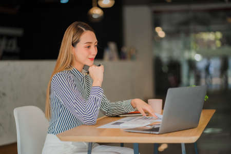 Asian business woman working on laptop computer in her workstation, startup, businessperson, employee, marketing concept, account, online finance, ecommerce, freelance.の写真素材