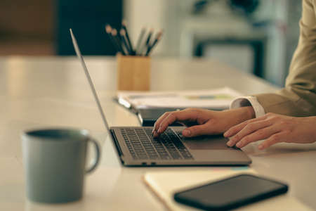 Close-up of businessman using blank screen digital tablet at desk while searching for business...
