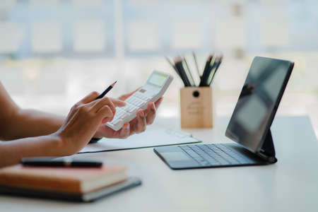 Close-up of businessman using blank screen digital tablet at desk while searching for business...