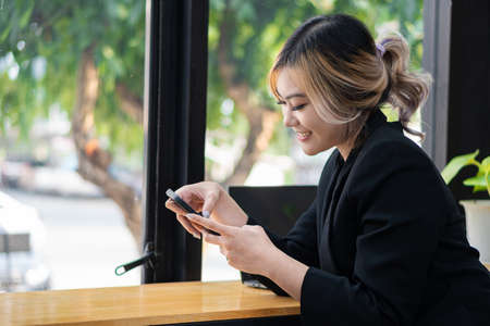 Asian woman shopping online retail store ecommerce using credit card debit card mobile smartphone payment money transfer technology purchasing product beautiful happy smileの写真素材