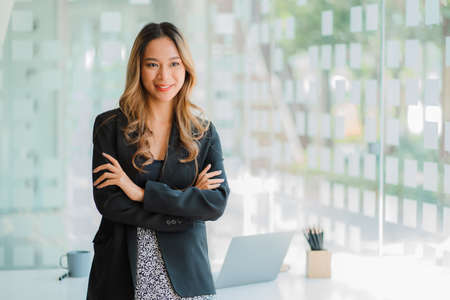 Freelance young Asian businesswoman working on laptop computer in modern office. make an account...