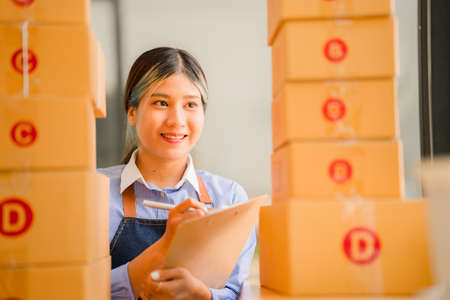 Asian owner, independent, SME business, online shopping Work on a laptop computer with a parcel box. Concept and delivery of an online SME businessの写真素材