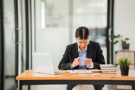 Analyzing data figures to plan business strategies Young Asian businesswoman as a business executive Founder and Managing Startup female business leader Startup business ideaの写真素材