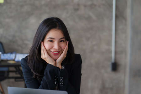 Happy Asian businesswoman using laptop computer while doing financial work. Successful with financial documents on the tableの写真素材