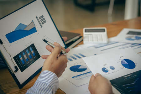 Business people meeting to analyze and discuss and brainstorm data, charts, financial reports and...