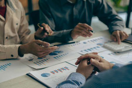 Business people meeting to analyze and discuss and brainstorm data, charts, financial reports and accounting in concept financial advisory office. teamworkの写真素材