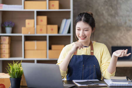 Small Business Startup SME Owners Asian Women Also Check Online Orders Laptops and sales of work items with girl boxes. Work independently at home, online SME business, small and mの写真素材