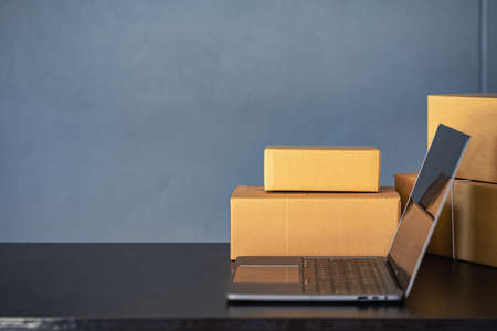 on the table with laptop and yellow cardboard box sme business conceptの写真素材