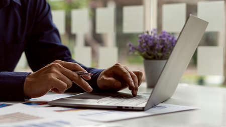 Businessman financial analysis with laptop and accounting report graph with calculator