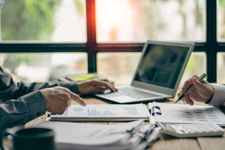 Asian business advisor meeting to analyze and discuss the situation of financial reports in the meeting room for financial investment advisors, accounting concepts.の写真素材