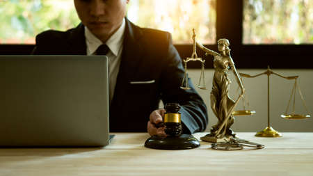 Asian male lawyer with legal services concept at online legal counseling office with hammer and...
