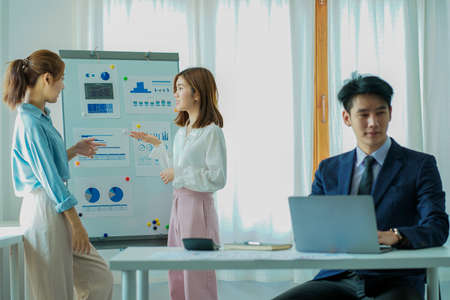 A group of cheerful modern Asian businessmen working together. Sit at a table discussing new project...