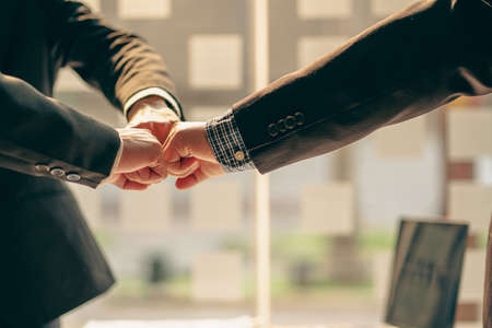 Successful colleagues put their naughty hands with fists together in the financial business idea office.の写真素材