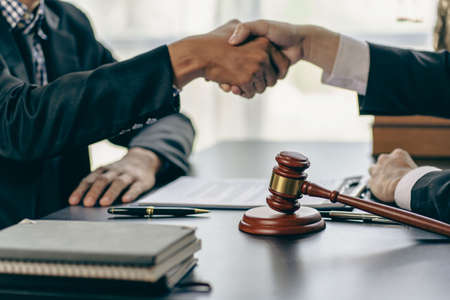 Businessmen shake hands to seal an agreement with a partner lawyer or lawyer who discusses the terms of the contract. The concept of a businessman's legal advisor.の写真素材