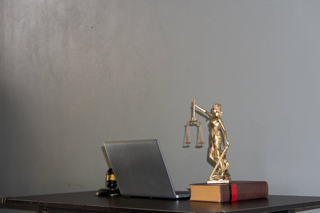 The concept of the law with a judge's hammer and scales. Goddess of Justice with laptop and tiger skins on lawyer's desk.の写真素材