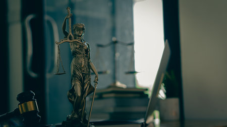 The concept of the law with a judge's hammer and scales. Goddess of Justice with laptop and tiger skins on lawyer's desk.の写真素材