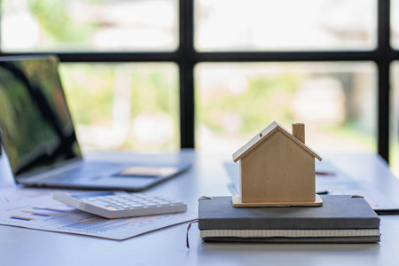 Real estate sales office with example of a house on a businessman's desk.の写真素材