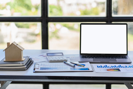 Real estate sales office with example of a house on a businessman's desk.の写真素材
