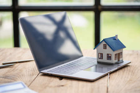 Real estate sales office with example of a house on a businessman's desk.の写真素材