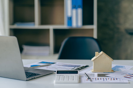 Real estate sales office with example of a house on a businessman's desk.の写真素材
