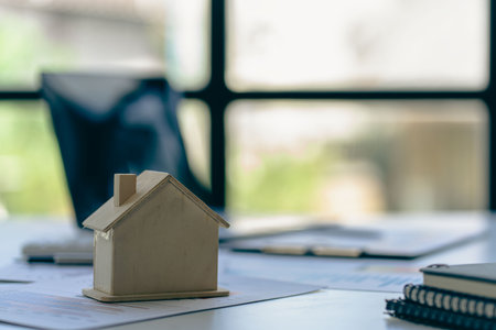 Real estate sales office with example of a house on a businessman's desk.の写真素材