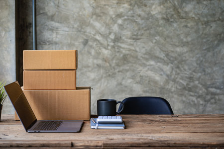 sme business idea with yellow box and laptop on desk in home officeの写真素材