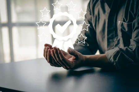 A check mark in hand with a star shows a virtual approved check mark.の写真素材