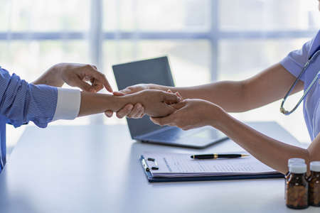 Doctors and patients provide consultation and diagnosis by sitting and talking. at the hospital medical concept deskの写真素材