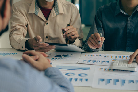 Asia business advisors meeting to analyze and discuss financial reports situation in the meeting room for financial investment advisors of businesses.の写真素材