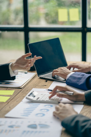 Business team working on calculators and business graph charts. financial accountant assistant Sales manager or marketer in formal attire vertical pictureの写真素材