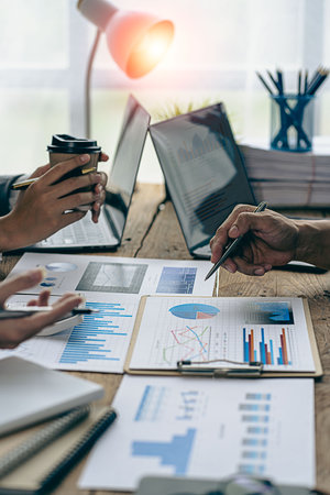 Business team working on calculators and business graph charts. financial accountant assistant Sales manager or marketer in formal attire vertical pictureの写真素材