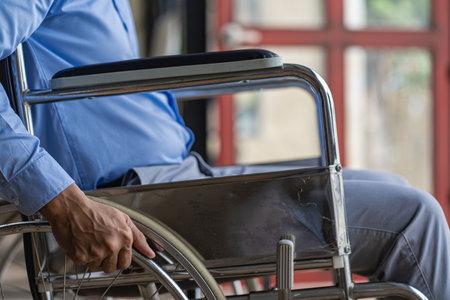 Businessman in a wheelchair working in the office at homeの写真素材