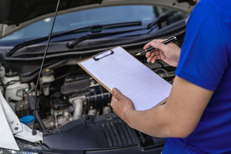 A young man checks the oil level and repairs the car before leaving.