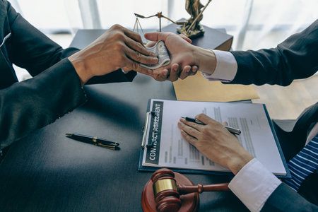 An attorney or officer accepts bribes from clients in the courtroom. Taking bribes to gain an advantage in lawsuits and want to win the concept of corruption and briberyの写真素材
