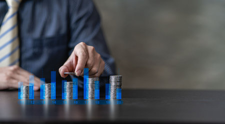 business growth idea a pile of coins and a blue piggy bank placed in front of a businessman with a financial graphの写真素材