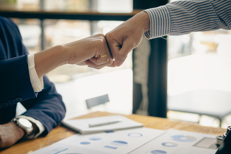 business people shake hands to make an agreement during a board meeting in the office Teamwork, agreement, cooperation, real estate business concept.の写真素材