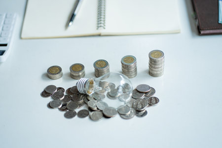 Energy-saving lamps and stacks of coins on the table Finance and Savings Ideas energy saving lampの写真素材