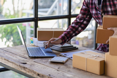 Young Startup Small Business SME Owner Male Entrepreneur Check online orders to prepare, pack boxes,...