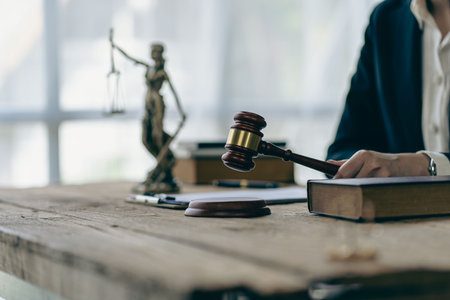 Lawyer working on contract documents and golden goddess scales with hammer on table providing advice, justice and legal counsel office concept images.の写真素材