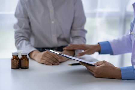 Doctors and patients sit and talk to patients about medications. At the table near the window in the hospital Consultation and advice conceptの写真素材