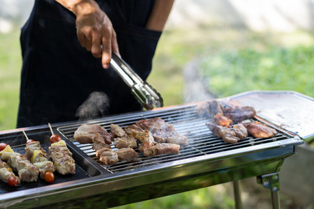 barbecue party food summer grilled meat Happy friends are having fun grilling meat, enjoying a barbecue party and beer celebration conceptの写真素材