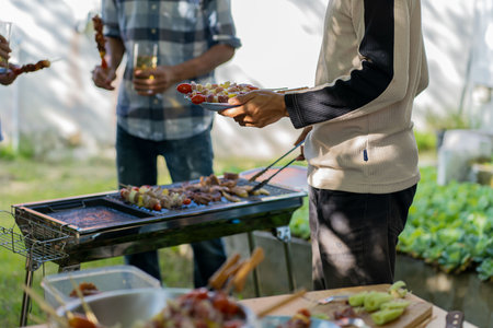 barbecue party food summer grilled meat Happy friends are having fun grilling meat, enjoying a barbecue party and beer celebration conceptの写真素材