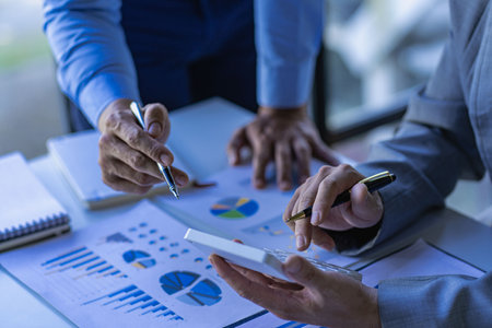 A team of business people working on financial analysis and marketing sales strategies in the...