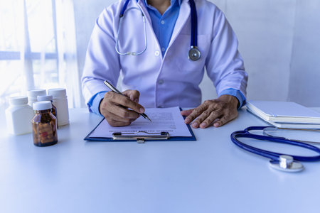Your doctor will write you a prescription and will be available to give you instructions on how to use it.
Close-up of pills opposite a female doctor sitting at a hospital table.の写真素材