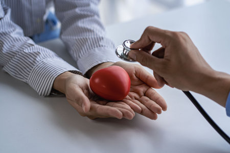 heart disease concept red heart in hand and doctor using stethoscope